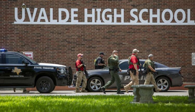 Law enforcement personnel walk outside Uvalde High School after shooting was reported earlier in the day at Robb Elementary School on Tuesday in Uvalde, Texas.