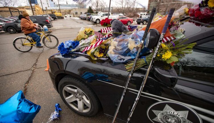 Flowers and other items cover slain Provo police officer Joseph Shinners' patrol car outside Provo Police Department's headquarters in Provo on Monday, Jan. 7, 2019. The trial for the man accused of shooting and killing Shinners was delayed on Wednesday.